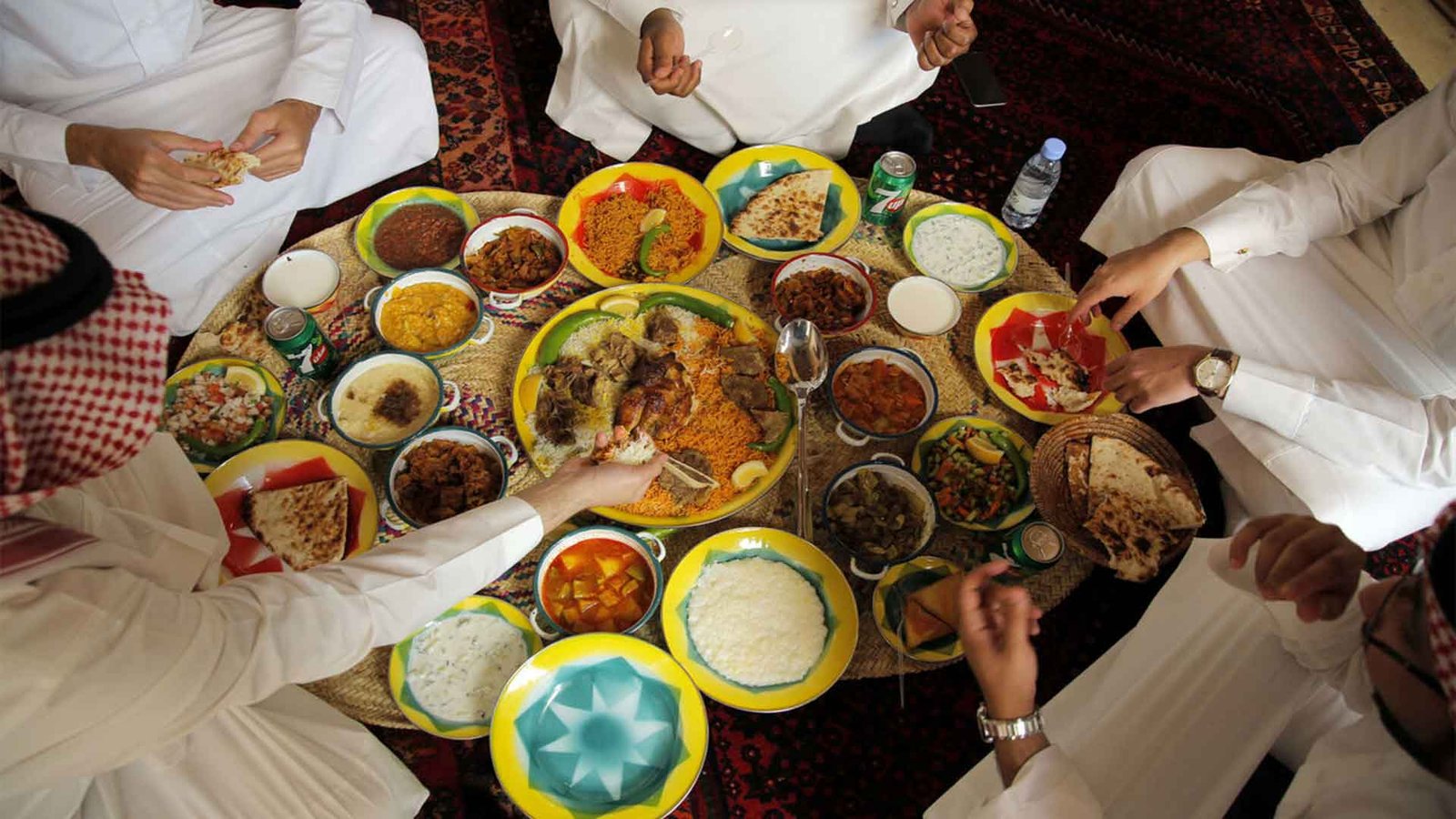 Traditional Omani meal served on the floor, with a variety of dishes shared among a group, illustrating the communal nature of Omani cuisine.