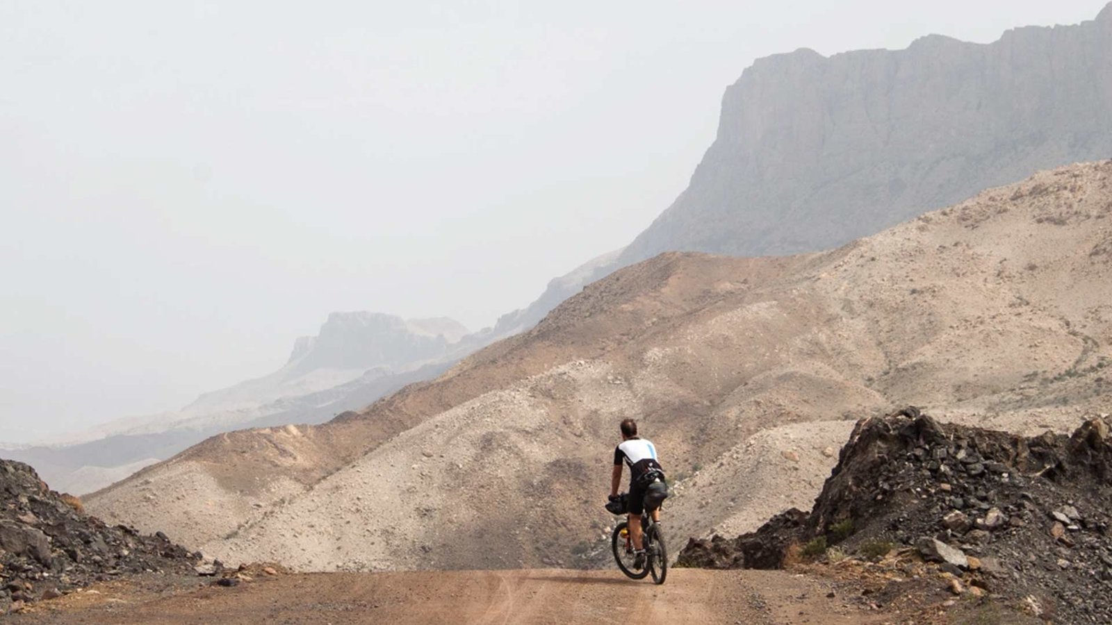 Mountain biker navigating the rugged terrain of Jebel Shams, Oman.