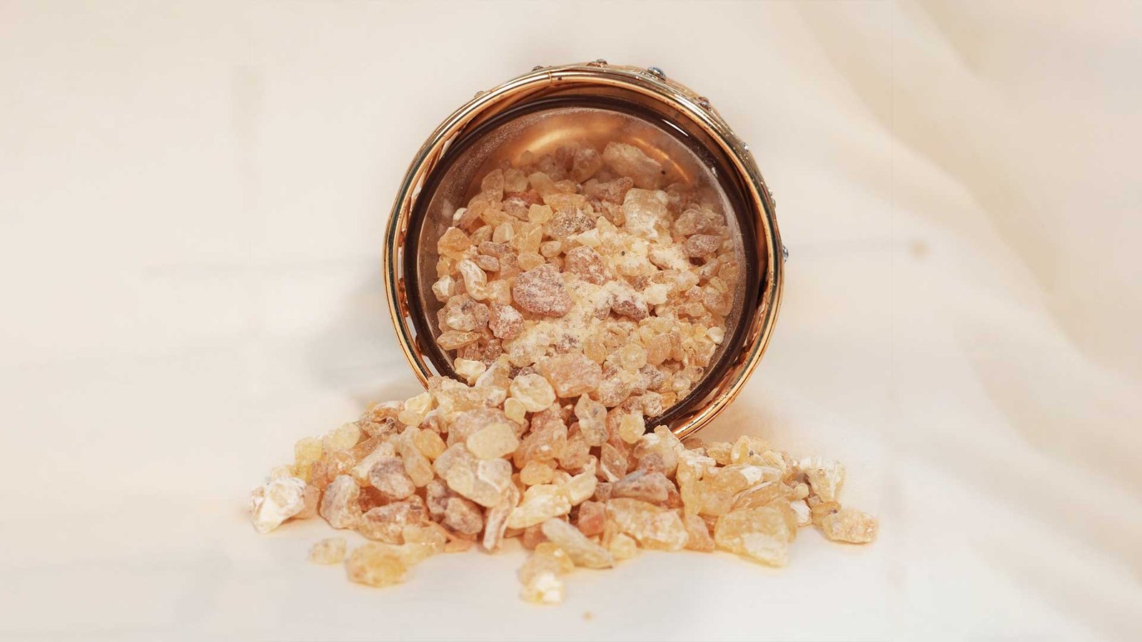 Traditional Omani frankincense, known as Luban, spilling from a brass container, highlighting its cultural significance in Omani cuisine and rituals.