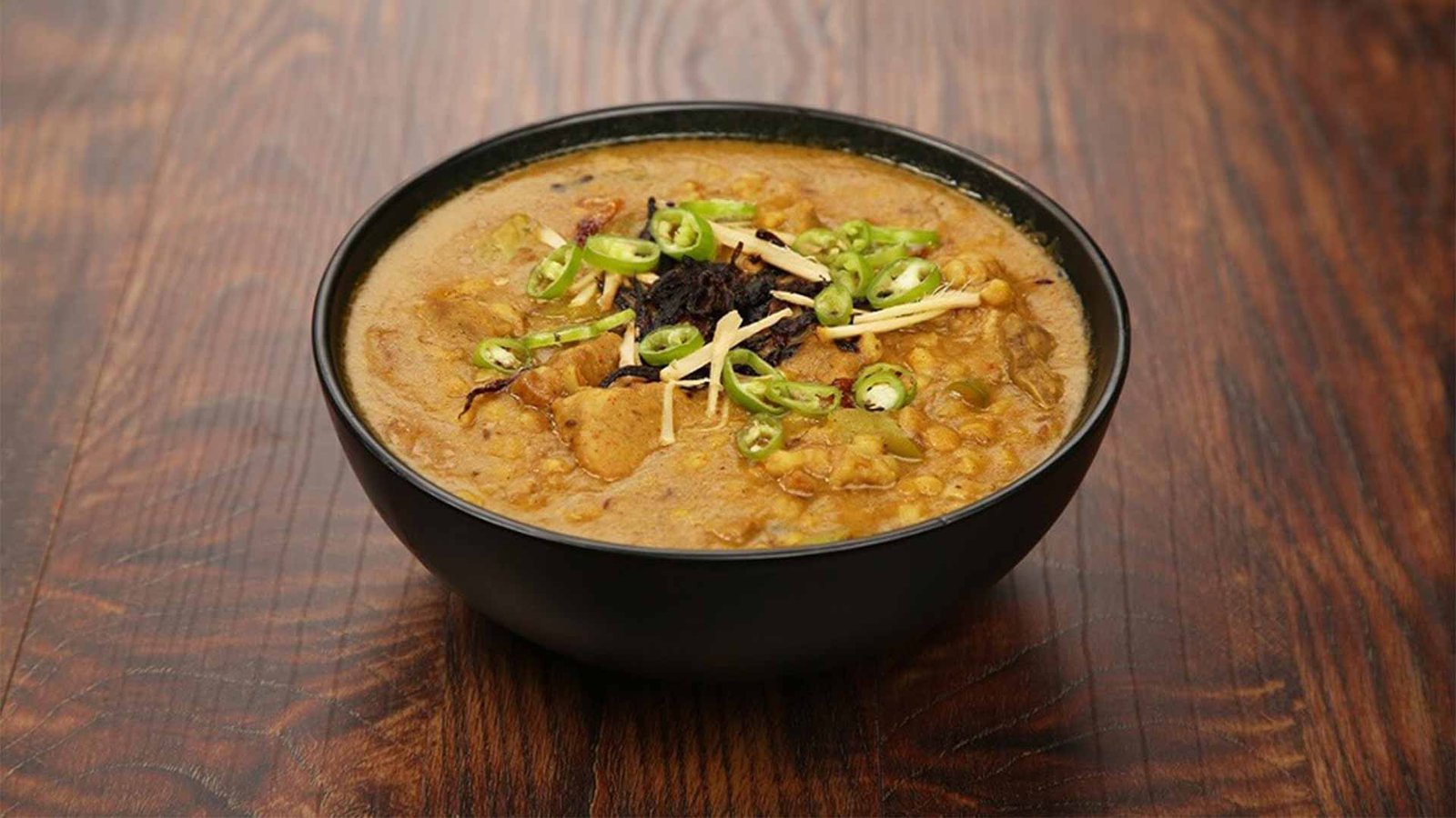 Bowl of Madrouba, a traditional Omani dish, showcasing the hearty and flavorful elements of Omani cuisine with tender meat and spices.