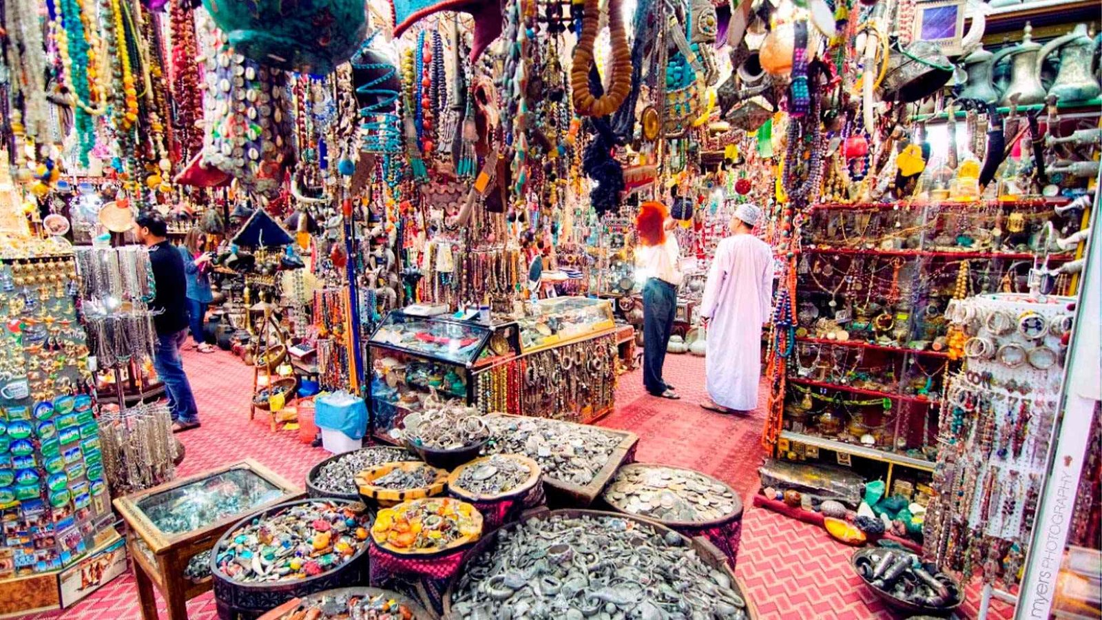 Vibrant view of Mutrah Souk with colorful stalls displaying traditional Omani spices, textiles, and jewelry.