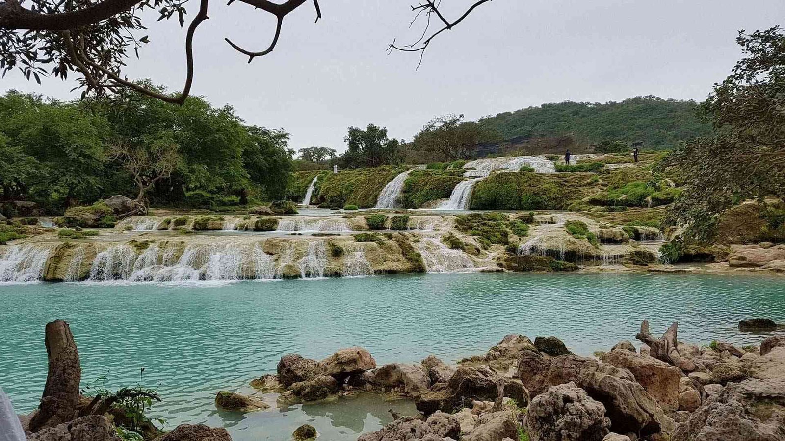 A tranquil scene of Wadi Darbat's waterfalls and greenery in Salalah, as seen in this Salalah travel guide.