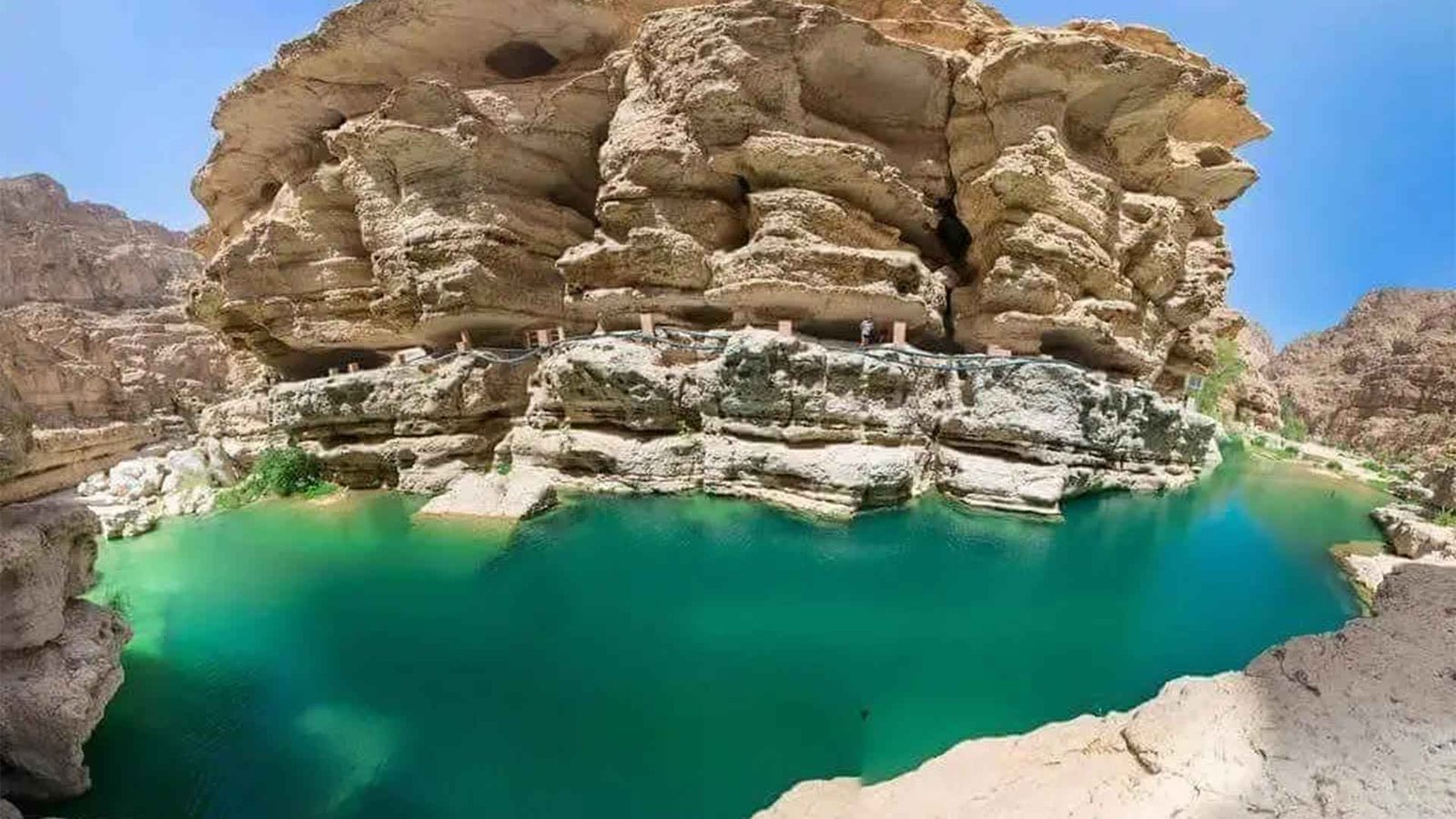 A breathtaking view of Wadi Shab in Oman, featuring clear turquoise pools surrounded by rugged cliffs.